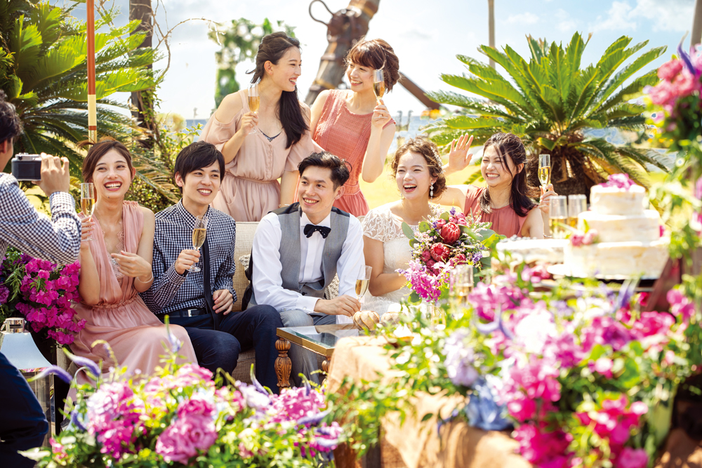 テラスでゲストとともに写真を撮る新郎新婦